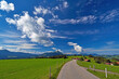 Landstraße im Allgäu Richtung Grünten unter blauem Wolkenhimmel
