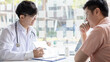© Puwasit Inyavileart - Young Asian man in a white robe talks to a man, Doctors diagnose diseases and give advice or treatment solutions to patients in the hospital examination room, Explaining medical examination results.