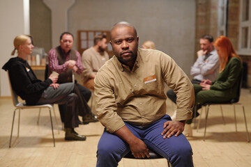 Poster - Bald serious man of African ethnicity looking at you against patients of mental support group