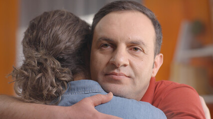 Holding on to the love of your life.  Close up view of loving couple hugging indoors. The happy man embraces the missed beloved woman as a symbol of tenderness and intimacy. 