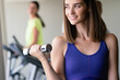 © NDABCREATIVITY - Portrait of a young happy fit woman with dumbbells