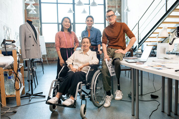 Poster - Successful fashion designers in casualwear standing by table in front of camera and looking at you