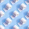 White toilet paper roll repeat seamless pattern on light blue background.