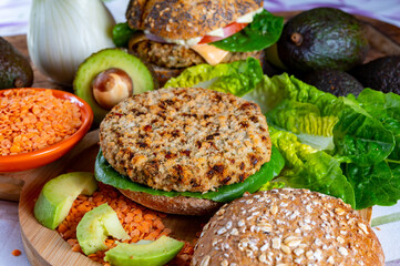 Wall Mural - Tasty vegetarian healthy food, homemade burgers made from orange lentils legumes with green lettuce and fresh ripe avocado