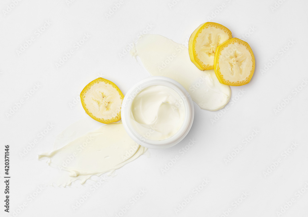 Jar of natural banana cream on white background