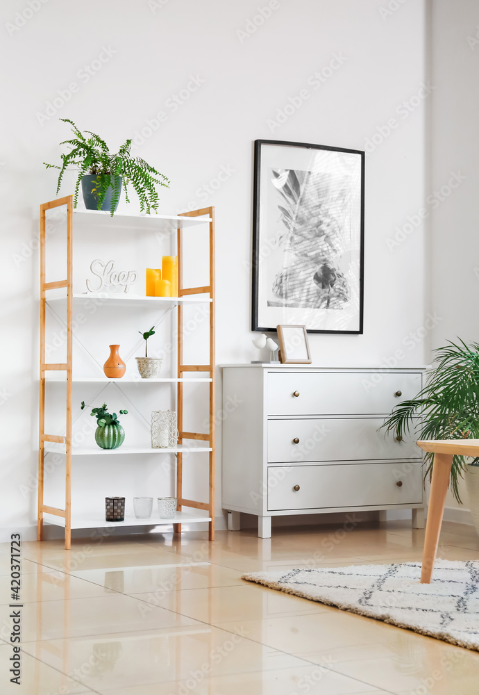 Shelving unit and chest of drawers in room