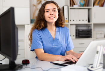 Wall Mural - Portrait of smiling and friendly doctor therapist at her desk in office in the hospital