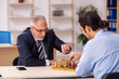 © Elnur - Two businessmen playing chess in the office