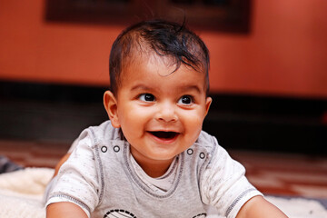 cute indian baby boy lying on a soft baby towel with smile