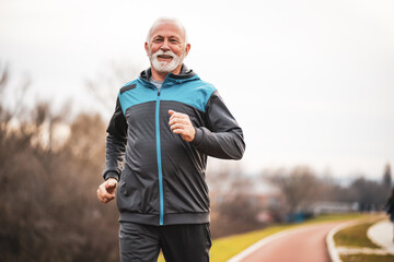 Active senior man is jogging. Healthy retirement lifestyle.