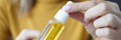 Woman holding jar of hair oil in her hands closeup