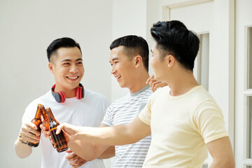 Sticker - Group of Asian friends toasting with bottles of beer during their meeting