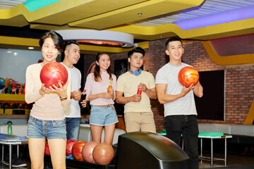 Poster - Group of Asian friends playing bowling together in entertainment center