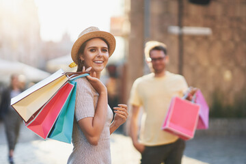 Wall Mural - Happy couple with shopping bags in the city