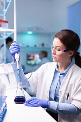 scientist looking into micropipette for biology test . woman research a new experiment in modern lab