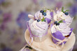 Vanilla cupcakes with lavender cream. Thematic muffins. Cupcakes with cream in a paper tulip form, decorated with blueberries, rosemary, flowers, tied with a ribbon.