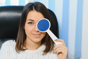 Young beautiful woman at the ophthalmologist's appointment checks her eyesight. Doctor ophthalmologist examines the patient