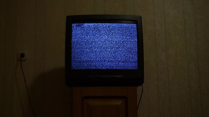 Wall Mural - Old retro tv with glitch snowy broadcast stands on wooden bedside table