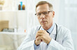 © Kostiantyn - Highly qualified doctor sitting at the table in clinic