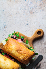 Canvas Print - Beef steak sandwich with ciabatta, arugula, tomato and parmesan on wooden board, top view. Comfort food concept.