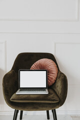 Wall Mural - laptop with blank copy space mockup screen display on lounge chair with pillow against white wall. f