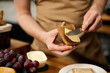 © Drazen - Close-up of man spreading butter on toasted bread while having breakfast.