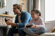 © opolja - family, gaming and entertainment concept - happy father and little daughter with gamepads playing video game at home.