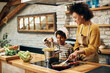 © Drazen - African American mother and son cooking together in the kitchen.