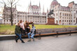 © Nona Liuter - Travel to Hungary, European tour. Tourists - Girls and a guy near the Hungarian parliament. A group of people are traveling across Europe.