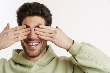 Wall Mural - Cheerful handsome man in sportswear covering his eyes