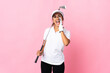 Young hispanic woman over isolated pink background playing golf and shouting with mouth wide open