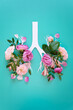 Medical concept of pink lilac flowers shaped in human lungs on blue background. Inflammation of the lungs concept, viral epidemic.