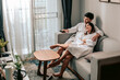 © Garun Studios - Asian couple watching television sitting on a sofa in the living room at home. Man is  holding a remote and looking to TV.Couple in Valentine day.Love couple,Relationship and couple concept.