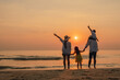 © Garun Studios - Happy asian family together on the beach in holiday.  of the family holding hands enjoying the sunset on the beach.Summer,Family and vacations concept.