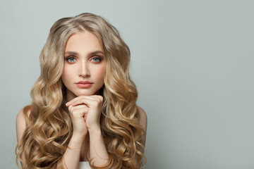 Wall Mural - young blonde woman with long healthy curly wavy hair on white background