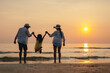 © Garun Studios - Happy asian family jumping together on the beach in holiday. Silhouette of the family holding hands enjoying the sunset on the  beach.Happy family and vacations concept.