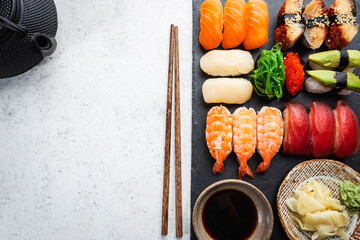 Wall Mural - Set of sushi and maki with soy sauce over white background. Top view with copy space