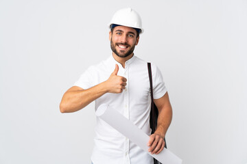 Poster - Young architect man with helmet and holding blueprints isolated on white background giving a thumbs up gesture