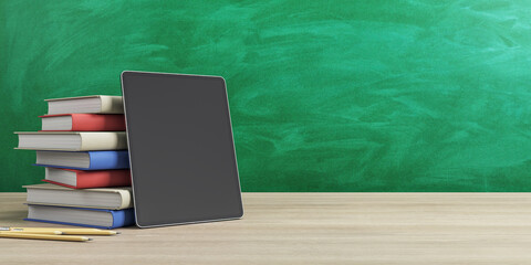 Poster - Online education concept with stack of books and digital tablet empty black screen on wooden table at green chalk board background. Mockup