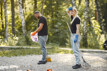 Couple collects garbage in garbage bags in park