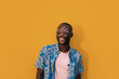 © MyMicrostock/Stocksy - Cheerful black man portrait on yellow wall
