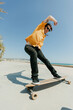 © Tadeu Dreyer/Stocksy - Young man skateboarding with a longboard in front of the beach