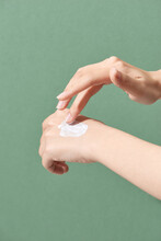 Cropped View Of Woman Applying Hand Cream Isolated On Green
