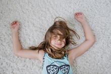 Beautiful Young Girl Laying On A Shag Rug With Hair Over Her Face