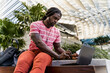 © Mauro Grigollo Photographer/Stocksy - Black man working with his laptop outdoor