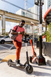 © Mauro Grigollo Photographer/Stocksy - Black man unlocking an electric scooter to move faster