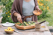 © Alberto Bogo/Stocksy - Anonymous Hand Making Fresh Salad With Wildflowers