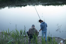 Guy And Girl With Fishing Rods On A Background Of Water