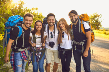 Wall Mural - company of cheerful hikers on road