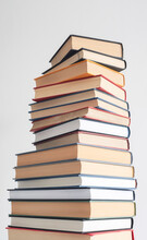 Tall Stack Of Hard Back Books In Various Shapes And Colours